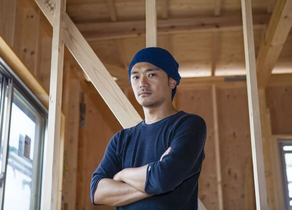 腕組みする大工